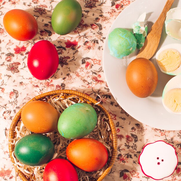 Bright Easter eggs on plates near salt can
