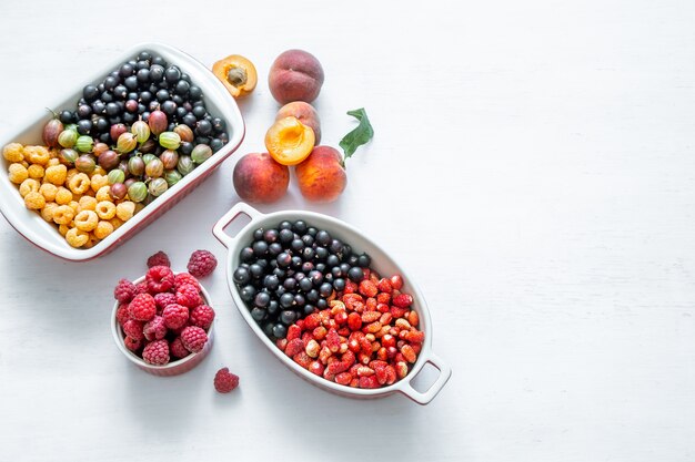 Bright fresh wild berries and peaches isolated top view. The concept of healthy eating.