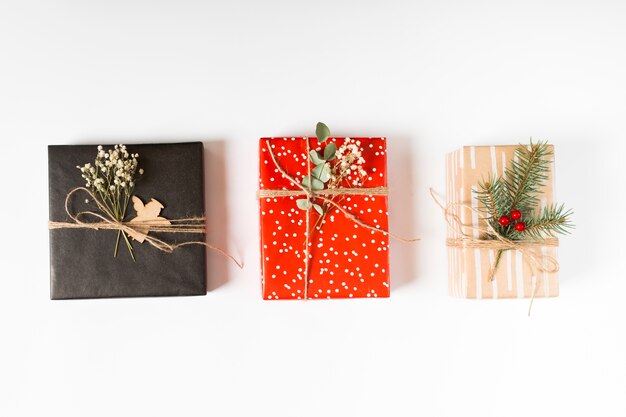 Bright gift boxes with branches on table 