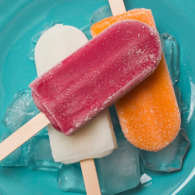 Bright ice lolly on plate with ice