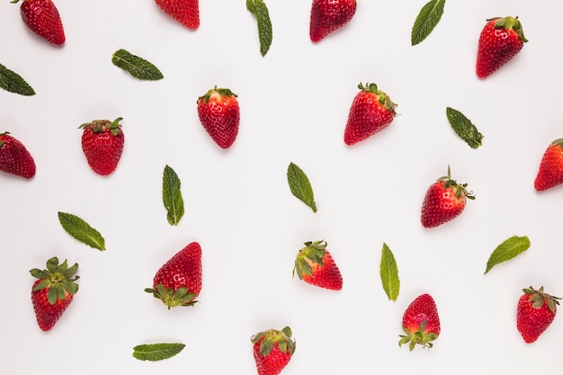 Bright juicy strawberries and green leaves on  white background