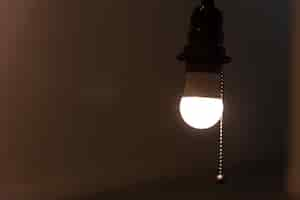 Foto gratuita una lampadina luminosa appesa in una stanza