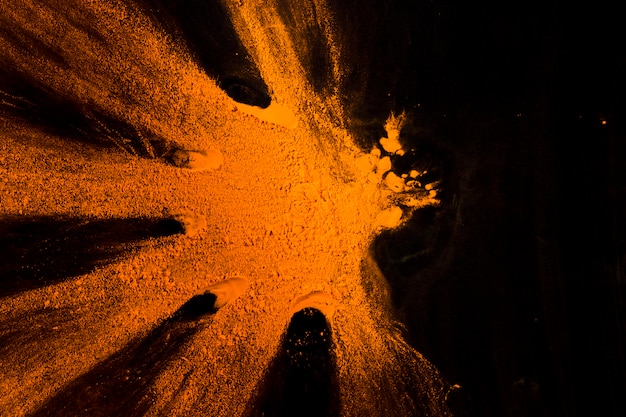 Bright orange holi powder over black background