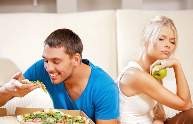Bright picture of couple eating different food (focus on man)