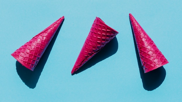 Free photo bright pink waffle cones on blue surface