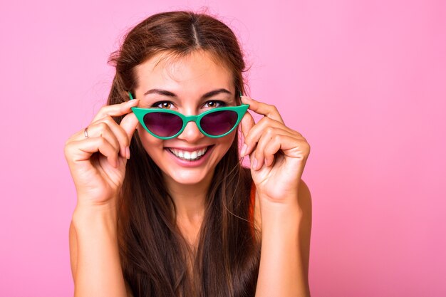 Bright Portrait of brunette young woman wearing trendy cat eye green sunglasses