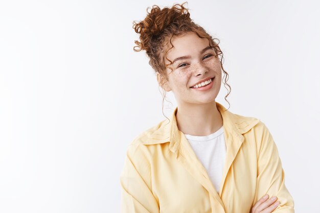 Bright positive happy good-looking young 20s female university student redhead freckles curly messy bun cross arms chest casual standing pose white background, smiling friendly enjoying chit-chat