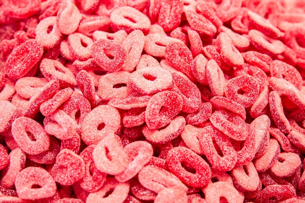 Bright red background with curly gummy gummy sweets