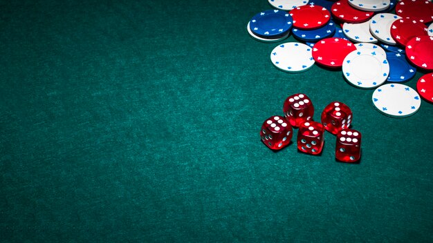 Bright red dices and casino chips on green poker background