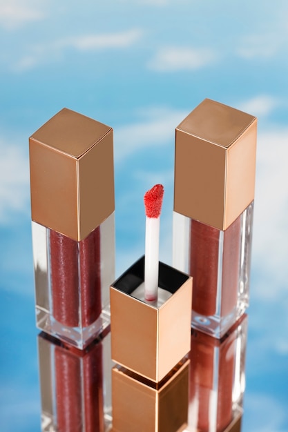 Bright red lip gloss with sky background high angle