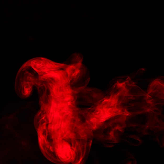 Ярко-красные пары дыма на черном фоне