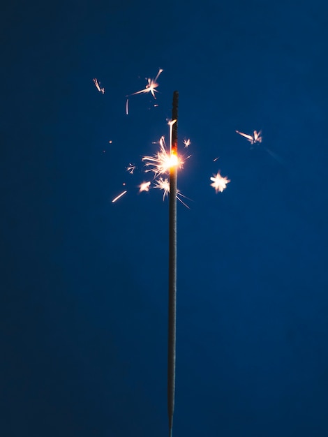 Free photo bright sparkler on blue background