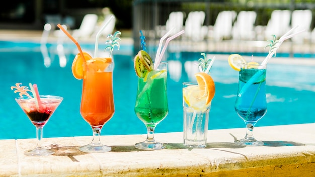 Bright summer cocktails near swimming pool