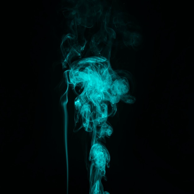 Bright turquoise smoke trail abstract black background