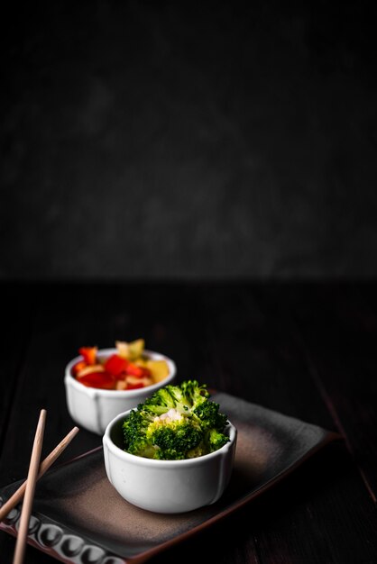 Broccoli and bell pepper in cups with chopsticks