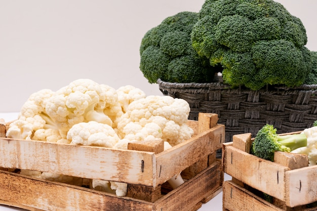 broccoli and cauliflower in wooden box and broccoli in basket