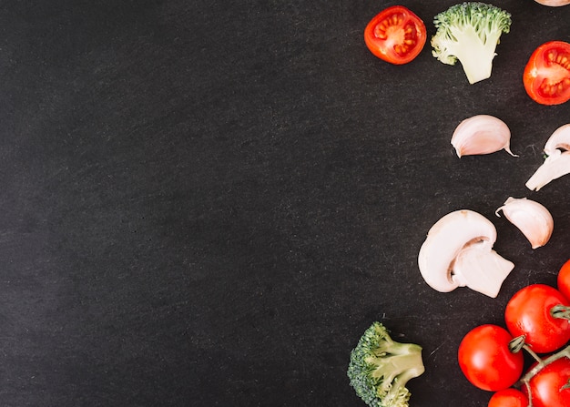 Free photo broccoli; cherry tomatoes; mushroom and garlic cloves on white textured background