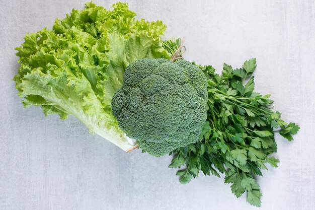 Broccoli, coriander leaves and lettuce on stone surface. High quality photo