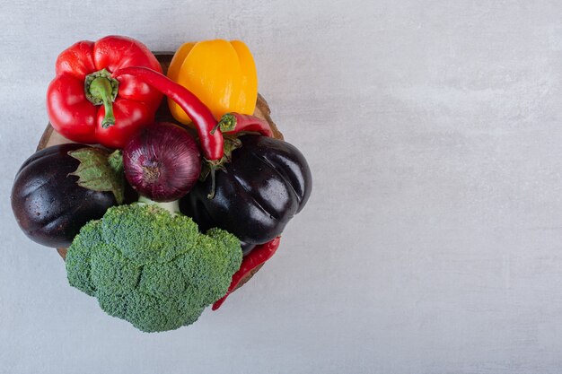 Broccoli, eggplants and peppers on wooden piece. High quality photo