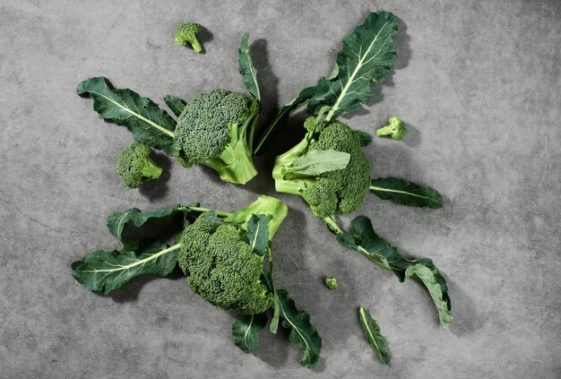 Foto gratuita infiorescenze di broccoli su disposte su uno sfondo grigio, vista dall'alto. prodotti vegetali sani, consegna cibo dalle fattorie