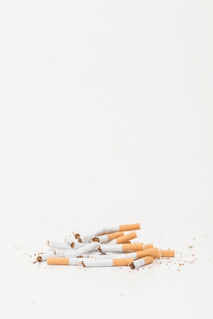 Сломанные сигареты на белом фоне с копией пространства для написания текста