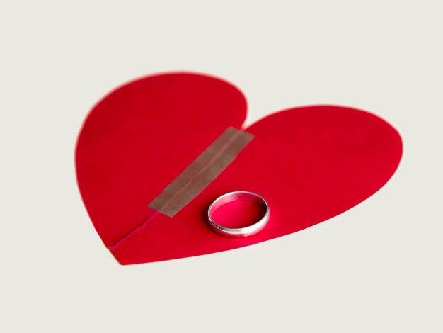 Broken paper heart with marriage ring