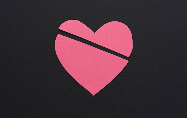 Broken pink heart on dark background