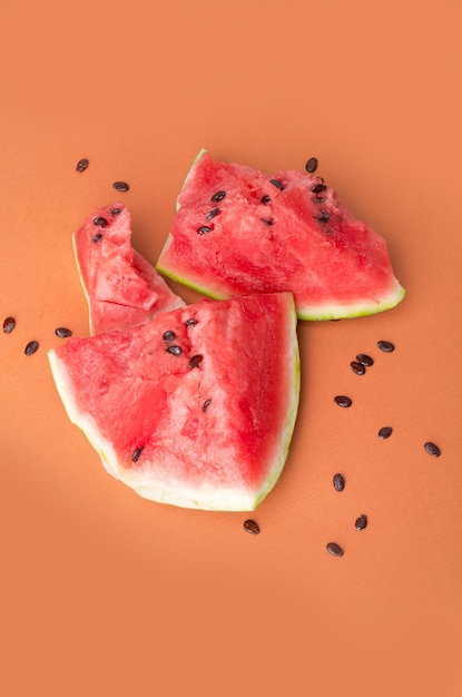 Free photo broken watermelon over orange surface