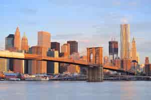 Foto gratuita ponte di brooklyn con lo skyline di manhattan al mattino con nuvole colorate sull'east river a new york city