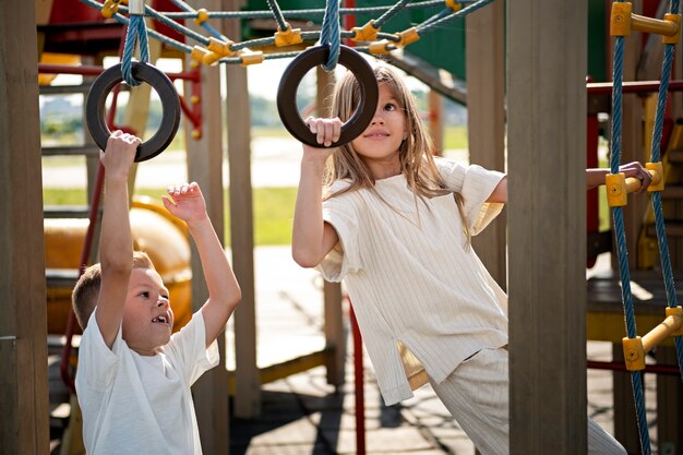 Brother and sister having fun at the outdoors playground