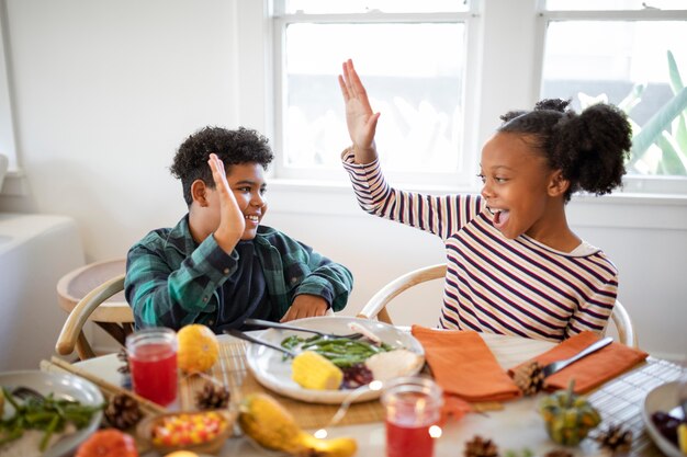 Brother and sister high fiving after the thanksgiving dinner