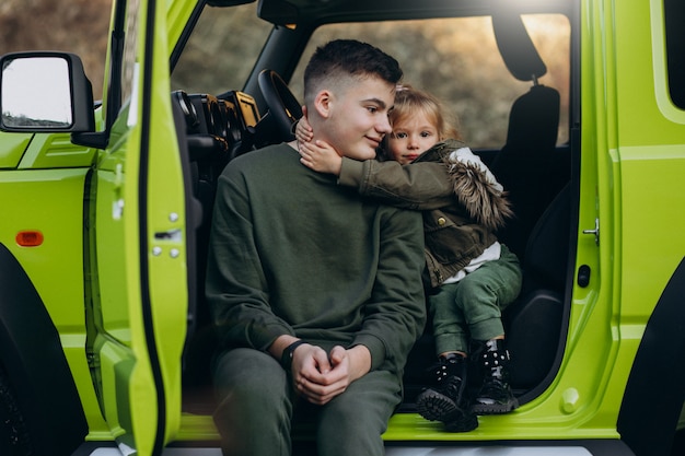 Brother with little sister sitting in green car