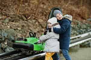 Free photo brother with sister at ride electric sleigh on rails