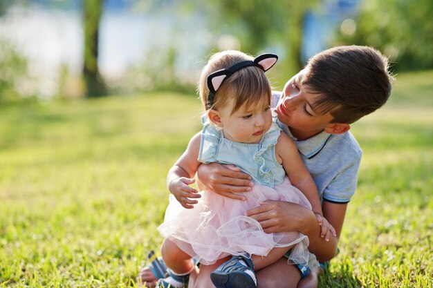 手のひらに対してトルコのリゾートで草の上に座っている姉妹と兄弟