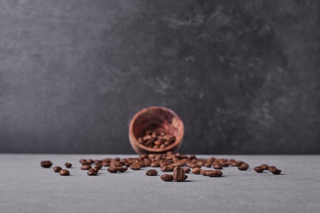 Brown arabica beans on grey background.