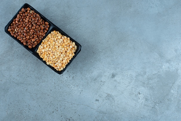 Brown beans and peas in black ceramic saucers. High quality photo