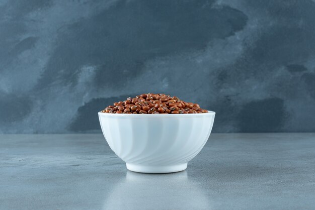 Brown beans in a white ceramic cup. High quality photo