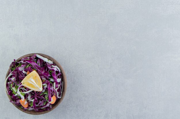 A brown bowl of mixed vegetables , on the marble background.