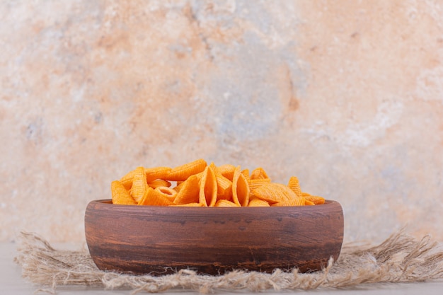 Brown bowl of triangle chips on white background. high quality photo