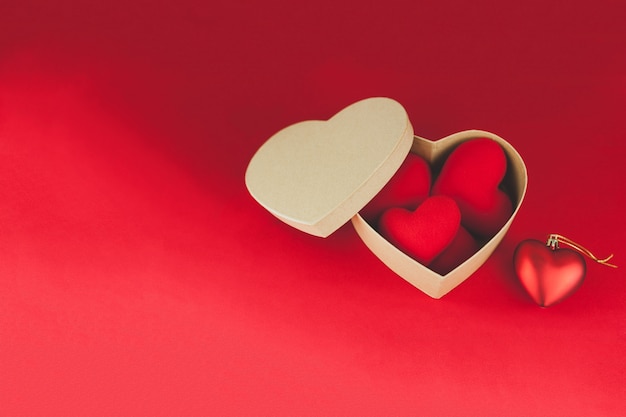Brown box with hearts inside on a red table