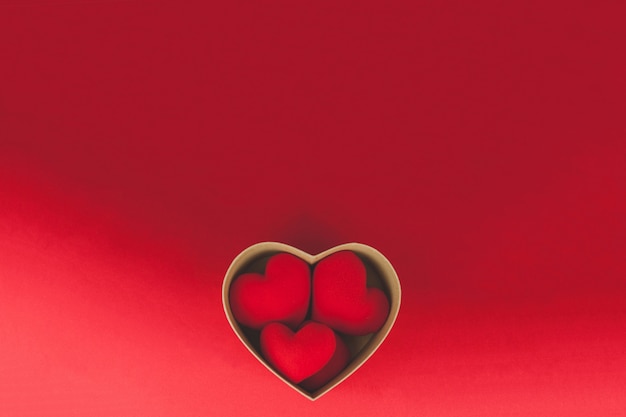 Brown box with hearts inside on a red table