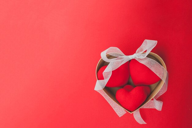 Free photo brown box with hearts inside and a white bow