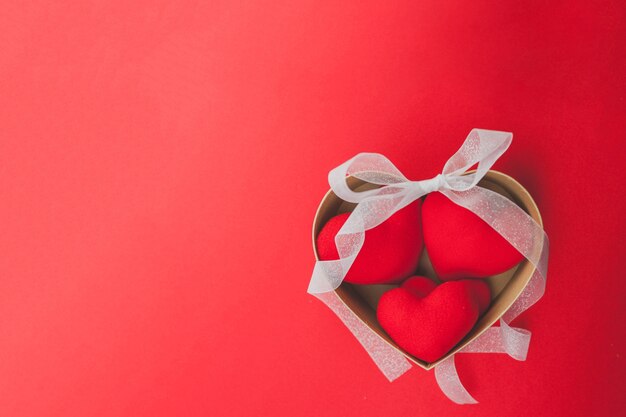 Brown box with hearts inside and a white bow