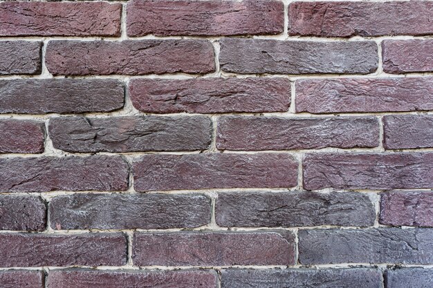 Brown brick wall. Texture of old dark brown and red brick with white filling