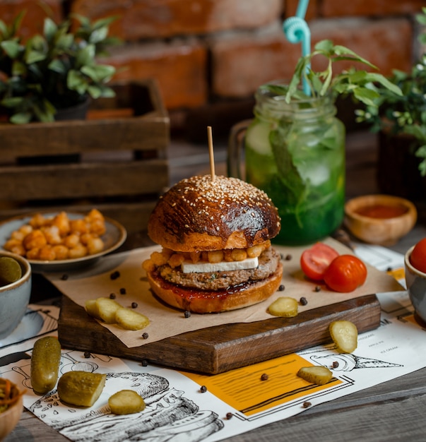 Brown bun burger with turshu on a wooden board