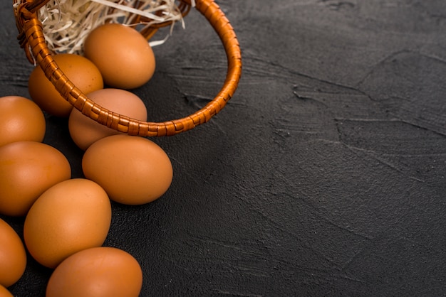 Brown chicken eggs with basket on table