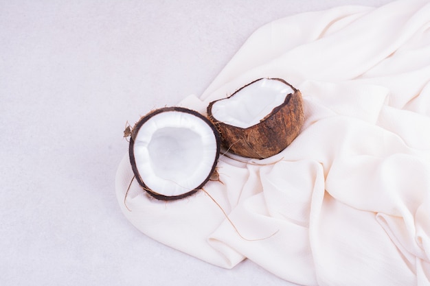 하얀 수건에 두 조각으로 자른 갈색 코코넛