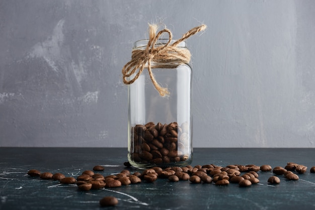 Brown coffee beans in a glass jar.