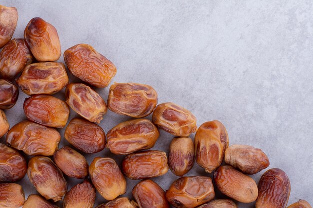 Brown dates isolated on concrete background. High quality photo