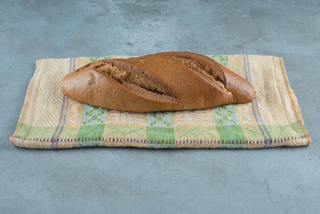 Brown delicious bread on colorful tablecloth.